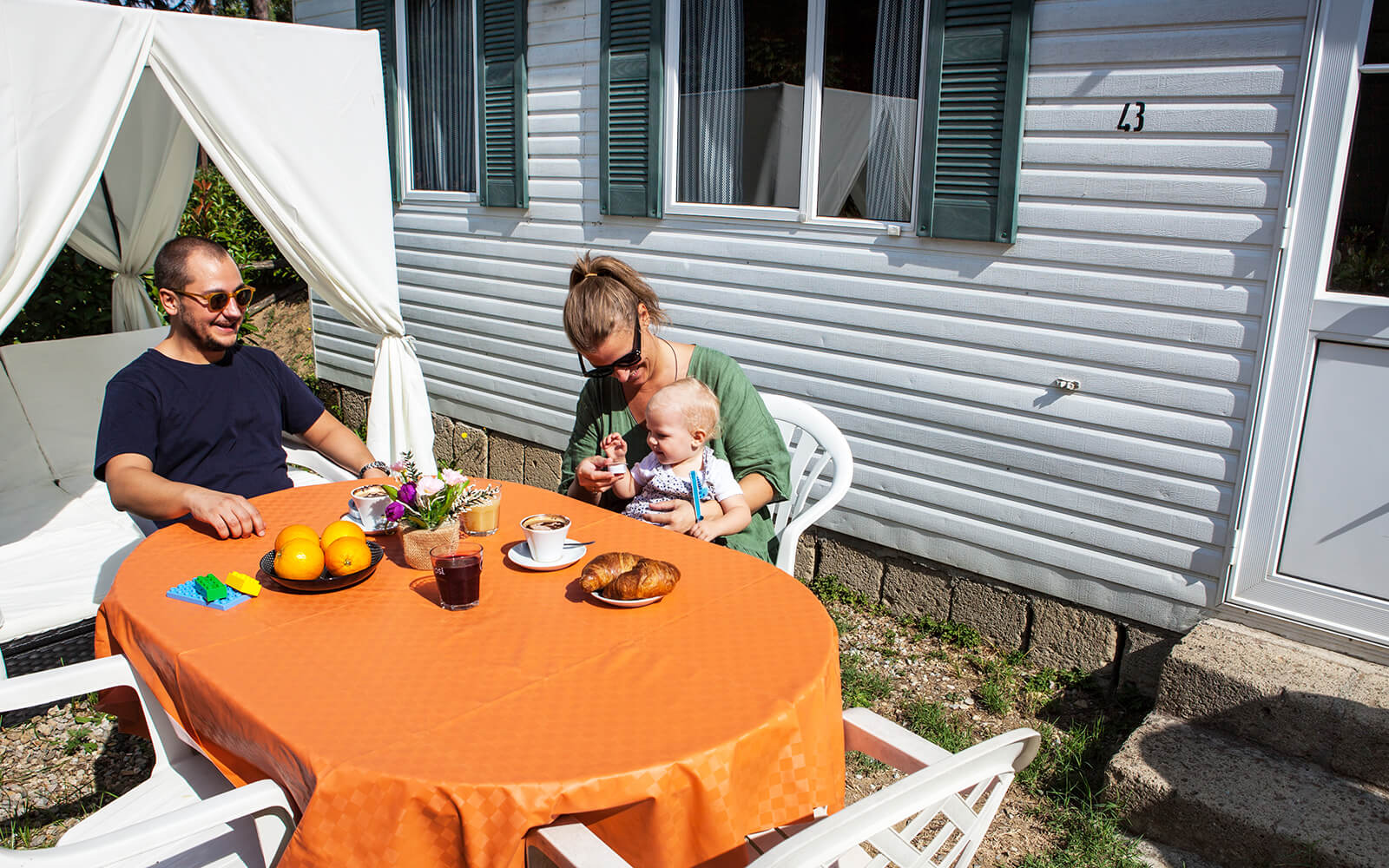 Family sitting at table outside holiday home